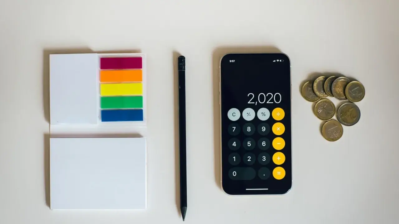 Kalkulator na telefonie pokazuje 2020, obok leżą monety euro. To może być początek oszczędzania na depozyt prosumencki.