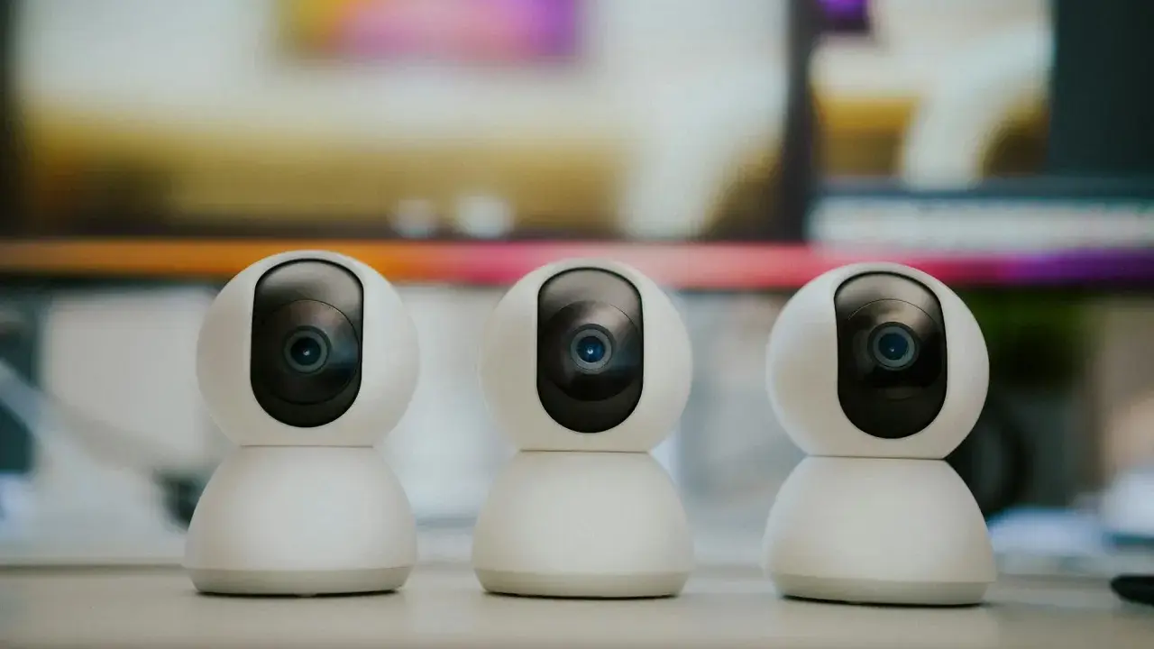 Trzy białe kamery monitoringu ustawione obok siebie. Dowiedz się, jak ustawić kamery monitoringu, by zapewnić bezpieczeństwo.