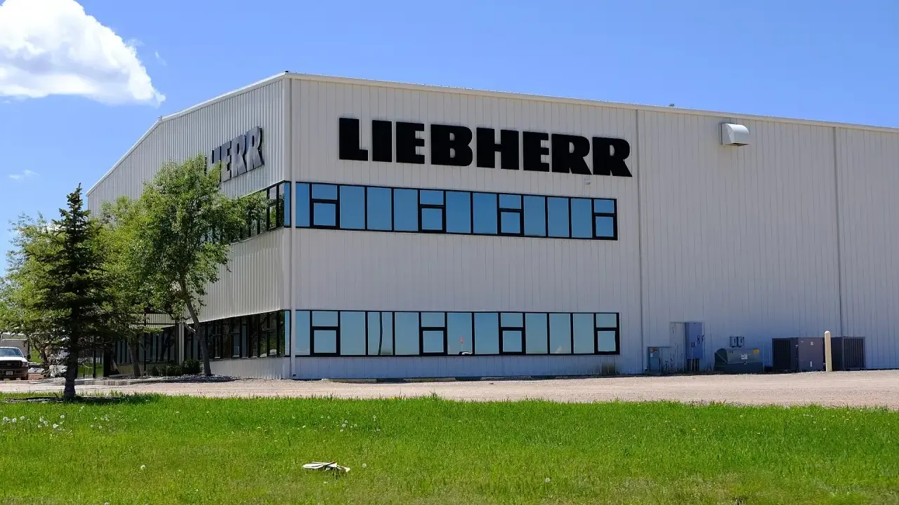 Fabryka Liebherr, gdzie produkowane są lodówki, to nowoczesny budynek z dużymi oknami i logo firmy.