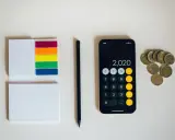 Kalkulator na telefonie pokazuje 2020, obok leżą monety euro. To może być początek oszczędzania na depozyt prosumencki.