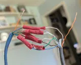 Połączenie przewodów sieciowych, aby przedłużyć kabel internetowy. Czerwone złączki zaciskowe łączą żyły.