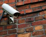 Kamera monitoringu na ceglanej ścianie. Czy do kamer potrzebny jest internet? Ta kamera jest podłączona kablem, więc niekoniecznie.