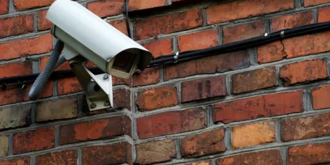 Kamera monitoringu na ceglanej ścianie. Czy do kamer potrzebny jest internet? Ta kamera jest podłączona kablem, więc niekoniecznie.