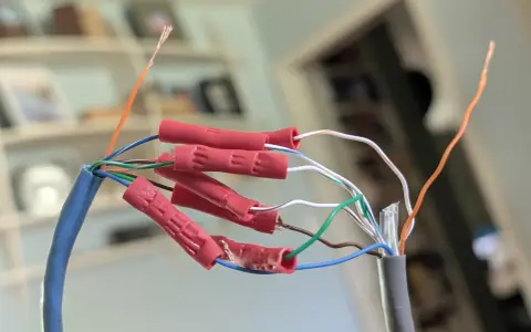Połączenie przewodów sieciowych, aby przedłużyć kabel internetowy. Czerwone złączki zaciskowe łączą żyły.