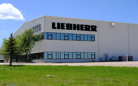 Fabryka Liebherr, gdzie produkowane są lodówki, to nowoczesny budynek z dużymi oknami i logo firmy.