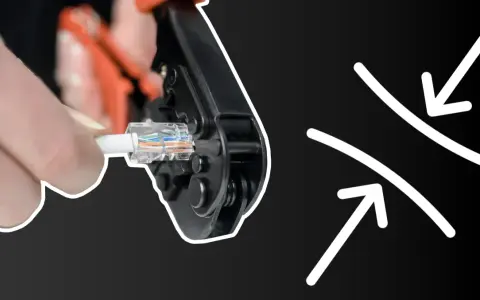 Dłoń zaciska wtyczkę RJ45 za pomocą narzędzia, pokazując, jak zacisnąć rj45.