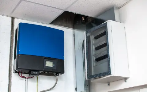 Montaż falownika i skrzynki z bezpiecznikami na ścianie. Instalacja elektryczna gotowa do pracy.