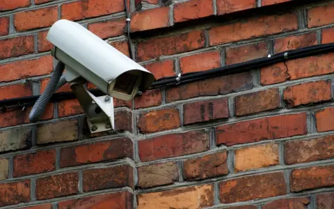 Kamera monitoringu na ceglanej ścianie. Czy do kamer potrzebny jest internet? Ta kamera jest podłączona kablem, więc niekoniecznie.