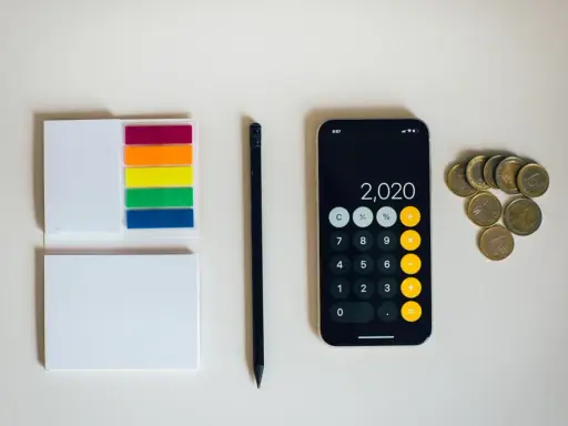 Kalkulator na telefonie pokazuje 2020, obok leżą monety euro. To może być początek oszczędzania na depozyt prosumencki.
