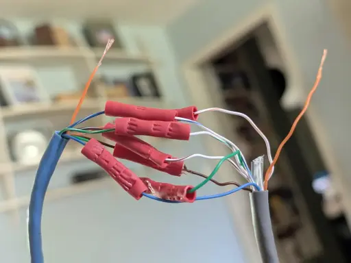 Połączenie przewodów sieciowych, aby przedłużyć kabel internetowy. Czerwone złączki zaciskowe łączą żyły.