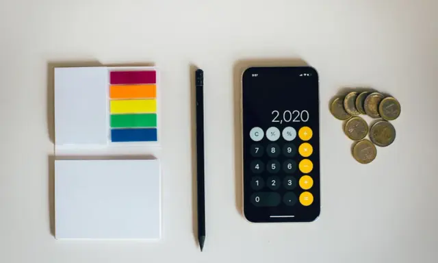 Kalkulator na telefonie pokazuje 2020, obok leżą monety euro. To może być początek oszczędzania na depozyt prosumencki.