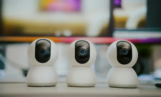 Trzy białe kamery monitoringu ustawione obok siebie. Dowiedz się, jak ustawić kamery monitoringu, by zapewnić bezpieczeństwo.