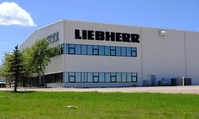 Fabryka Liebherr, gdzie produkowane są lodówki, to nowoczesny budynek z dużymi oknami i logo firmy.
