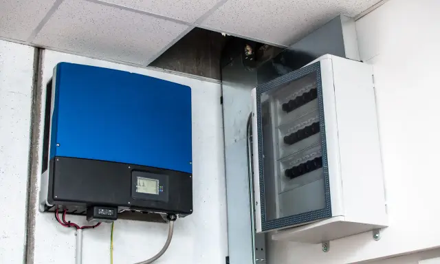 Montaż falownika i skrzynki z bezpiecznikami na ścianie. Instalacja elektryczna gotowa do pracy.