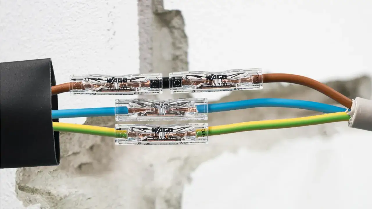 Jak połączyć przecięty kabel w ścianie? Złączki WAGO ułatwiają szybkie i bezpieczne połączenie przewod&oacute;w brązowego, niebieskiego i ż&oacute;łto-zielonego.