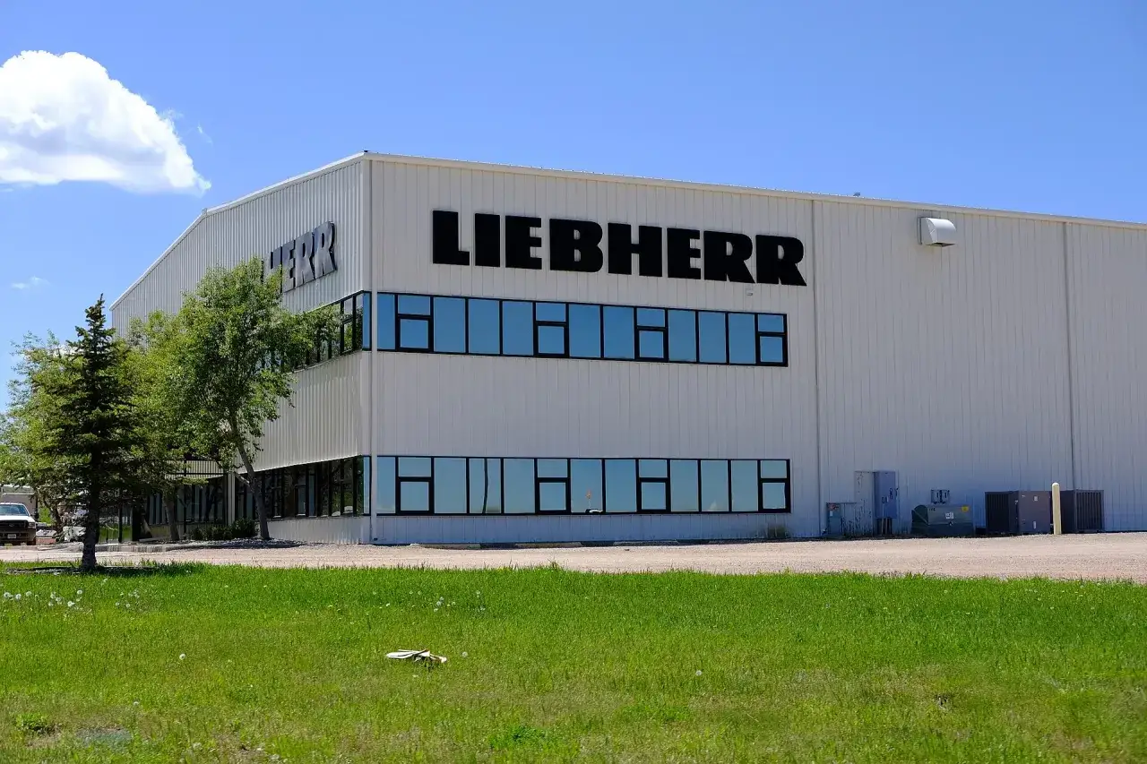 Fabryka Liebherr, gdzie produkowane są lod&oacute;wki, to nowoczesny budynek z dużymi oknami i logo firmy.