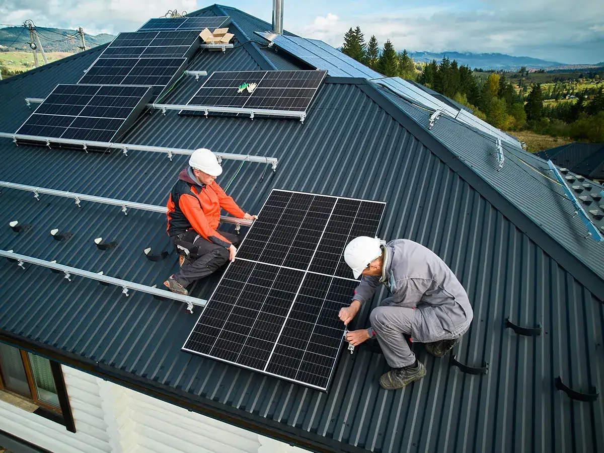 Montaż paneli fotowoltaicznych na dachu. Pracownicy firm fotowoltaicznych w Polsce instalują panele, zapewniając zieloną energię.