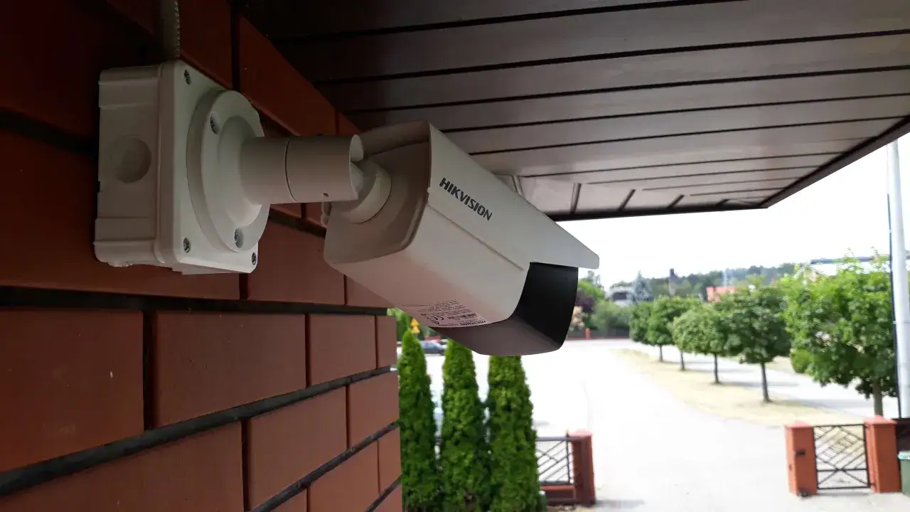 Kamera Hikvision zamontowana na ceglanej ścianie pod okapem. Dowiedz się, jak zamontować kamerę, by zapewnić bezpieczeństwo.